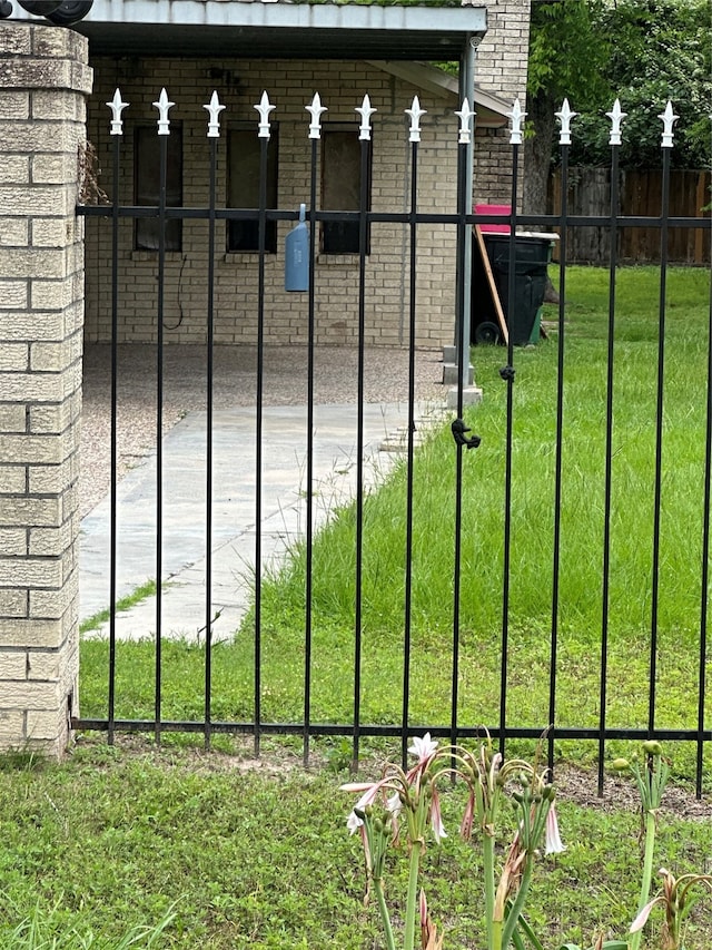 view of gate with a yard