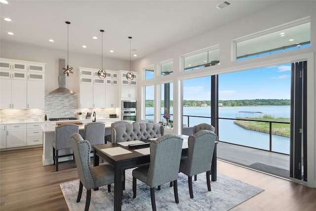 dining room featuring plenty of natural light, a water view, and wood finished floors