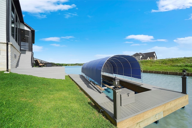 dock area with a water view, a lawn, and boat lift