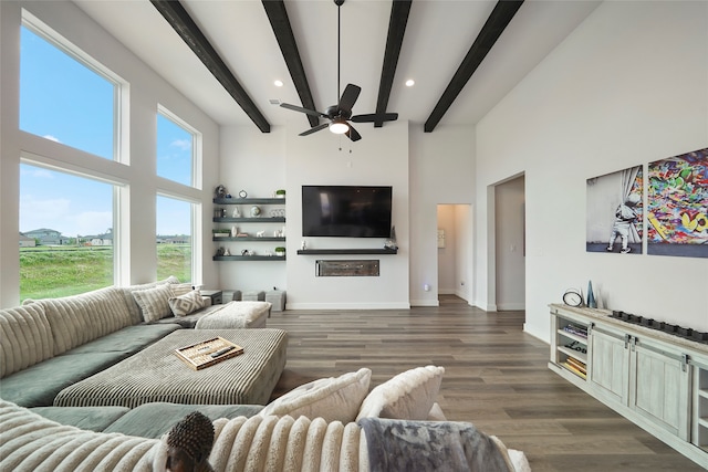 living room with a high ceiling, beamed ceiling, wood finished floors, and baseboards