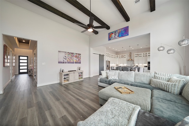 living room featuring high vaulted ceiling, a barn door, dark wood finished floors, and beam ceiling