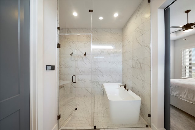 ensuite bathroom featuring tile walls, a soaking tub, a ceiling fan, a shower stall, and ensuite bath