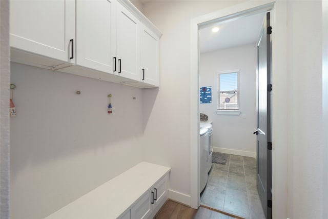 mudroom featuring light wood finished floors, baseboards, and washer and dryer