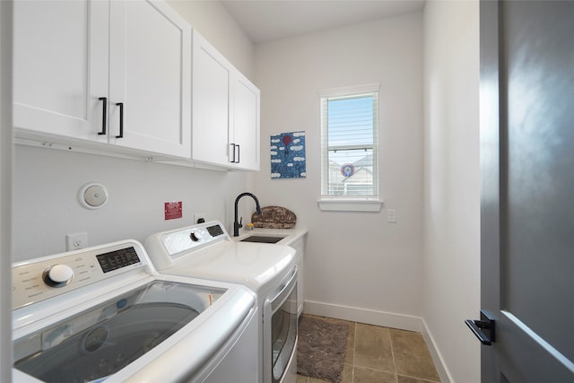 clothes washing area featuring baseboards, a sink, cabinet space, and washer and dryer