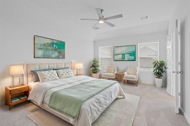 bedroom featuring multiple windows, vaulted ceiling, light colored carpet, and ceiling fan