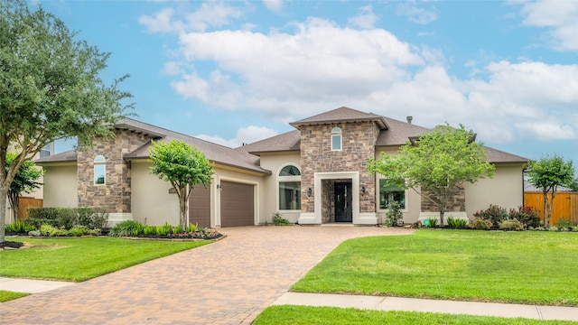 view of front of property with stone siding, decorative driveway, an attached garage, and a front yard