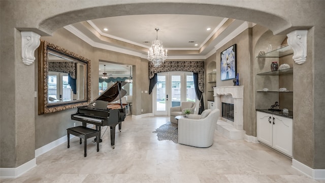 living area featuring built in shelves, a tray ceiling, french doors, and crown molding