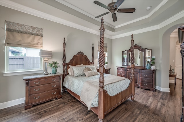 bedroom featuring dark hardwood / wood-style flooring, a tray ceiling, ceiling fan, and ornamental molding