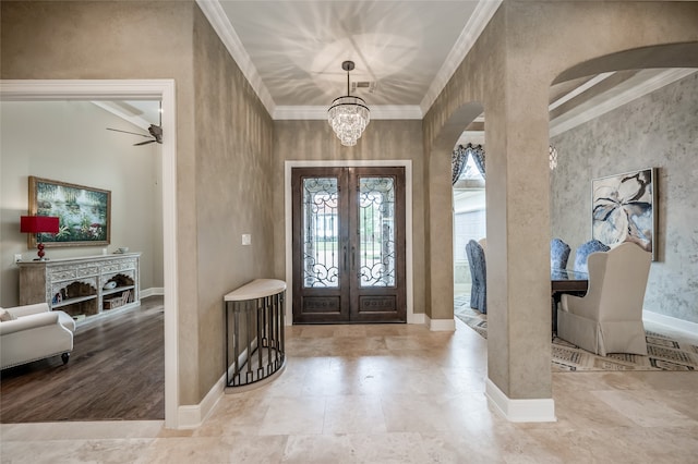 entrance foyer featuring crown molding, french doors, and a notable chandelier