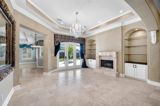 unfurnished living room with french doors, built in features, a high end fireplace, a chandelier, and a tray ceiling