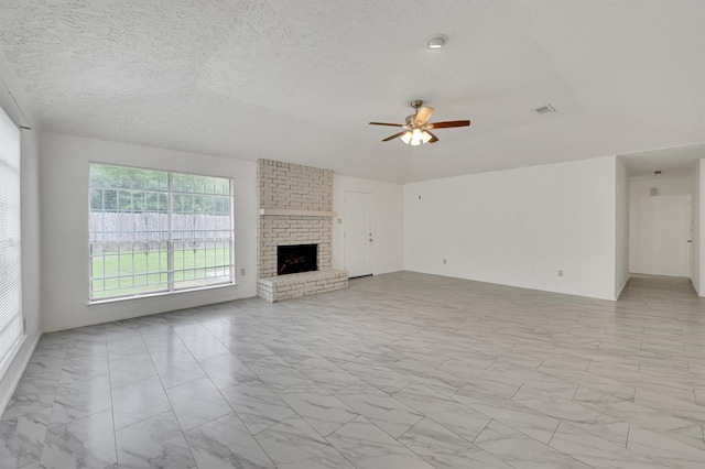 unfurnished living room with a fireplace, ceiling fan, brick wall, and light tile floors