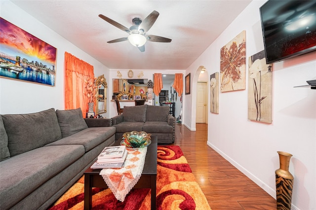 living room with wood-type flooring and ceiling fan