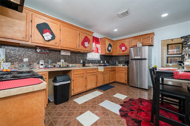 kitchen featuring backsplash, sink, appliances with stainless steel finishes, and light tile floors