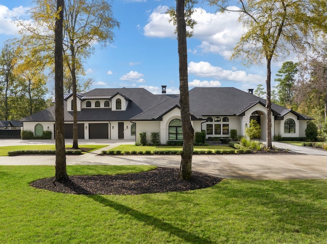 french country inspired facade featuring a front yard and a garage