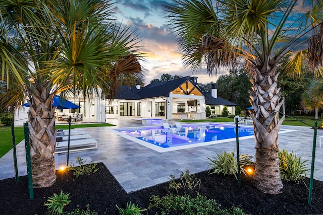 pool at dusk with a patio