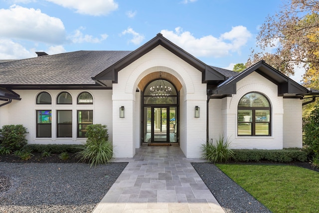 view of exterior entry with french doors and a yard