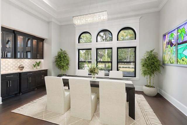 dining space featuring ornamental molding, dark hardwood / wood-style flooring, and an inviting chandelier