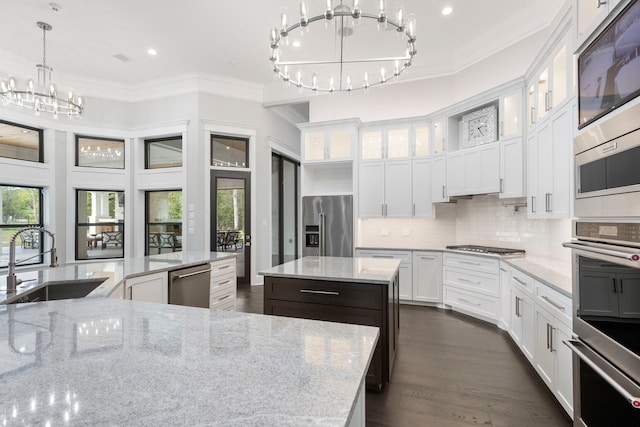 kitchen with appliances with stainless steel finishes, dark hardwood / wood-style floors, tasteful backsplash, sink, and a center island