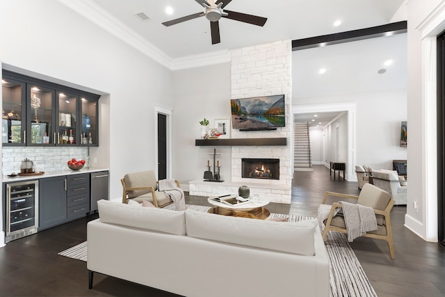 living room featuring wine cooler, dark wood-type flooring, ceiling fan, and a fireplace