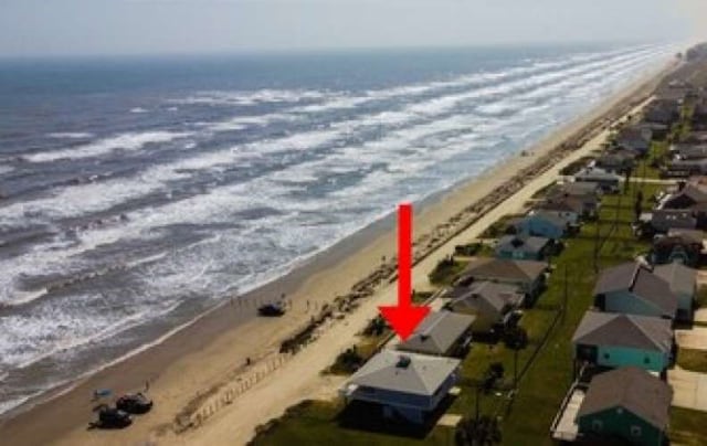 birds eye view of property with a view of the beach and a water view