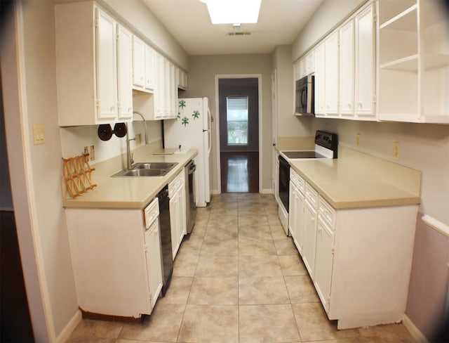 kitchen featuring sink, white cabinets, black appliances, and light tile floors