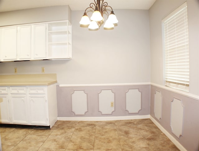 unfurnished dining area with a notable chandelier and light tile flooring