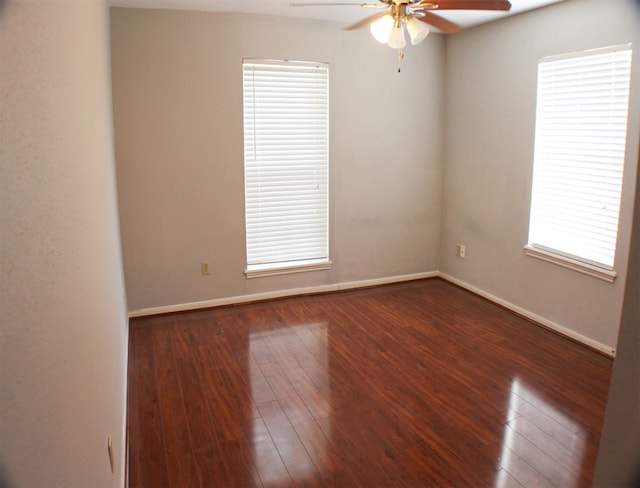 empty room with dark wood-type flooring and ceiling fan