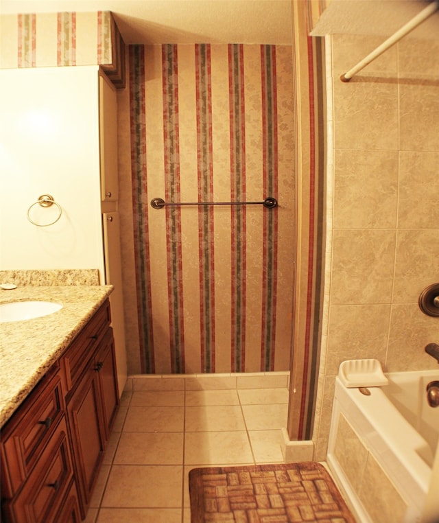 bathroom featuring tiled shower / bath combo, vanity, tile walls, and tile flooring