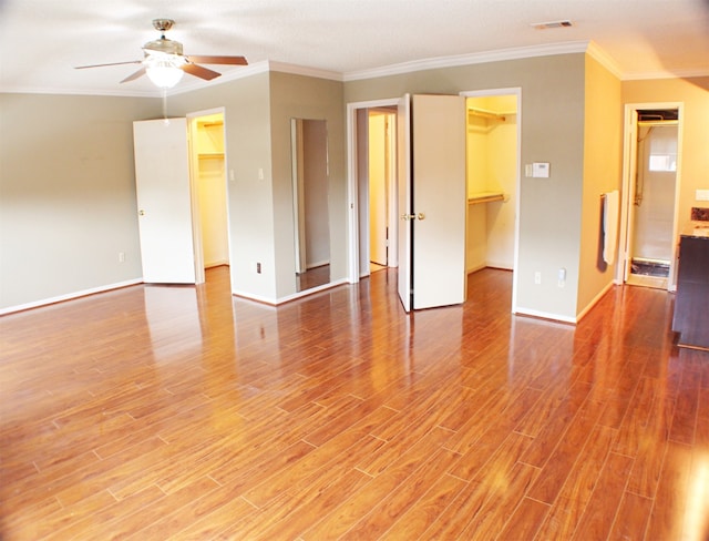 empty room with ornamental molding, ceiling fan, and light wood-type flooring