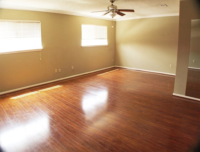 empty room featuring dark hardwood / wood-style floors, ceiling fan, crown molding, and a textured ceiling