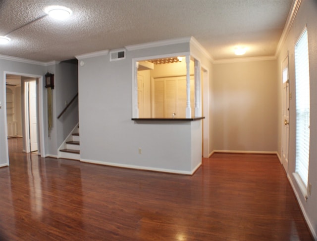 unfurnished room with a textured ceiling, dark hardwood / wood-style flooring, and ornamental molding