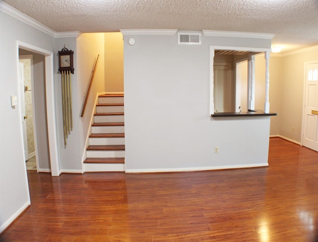 interior space featuring ornamental molding, a textured ceiling, and dark wood-type flooring