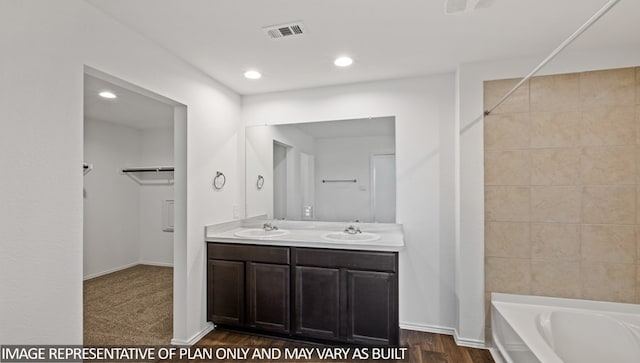 bathroom with a washtub, vanity, and hardwood / wood-style floors