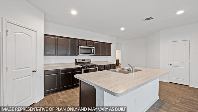 kitchen featuring dark brown cabinets, stainless steel appliances, sink, a center island with sink, and dark hardwood / wood-style floors