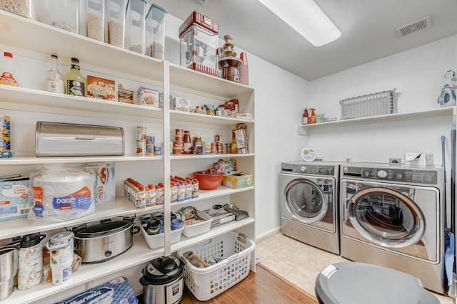 laundry area with light tile floors and washer and dryer