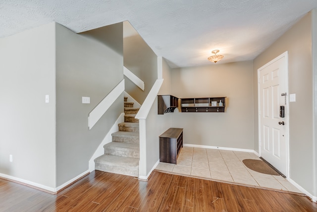 tiled entrance foyer with a textured ceiling