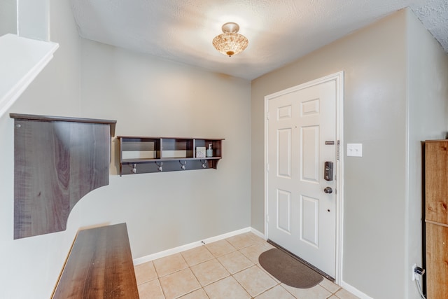 tiled entrance foyer featuring a textured ceiling