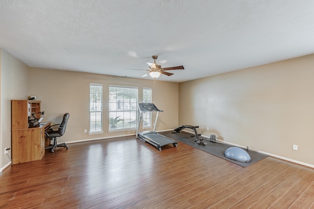 workout area with a textured ceiling, ceiling fan, and hardwood / wood-style floors