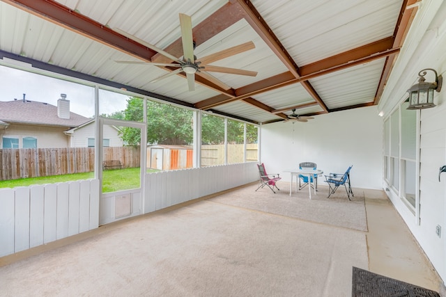 unfurnished sunroom featuring beam ceiling and ceiling fan