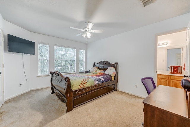 bedroom with ensuite bath, light colored carpet, and ceiling fan