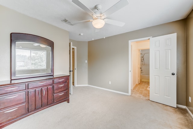 carpeted bedroom with ensuite bath and ceiling fan