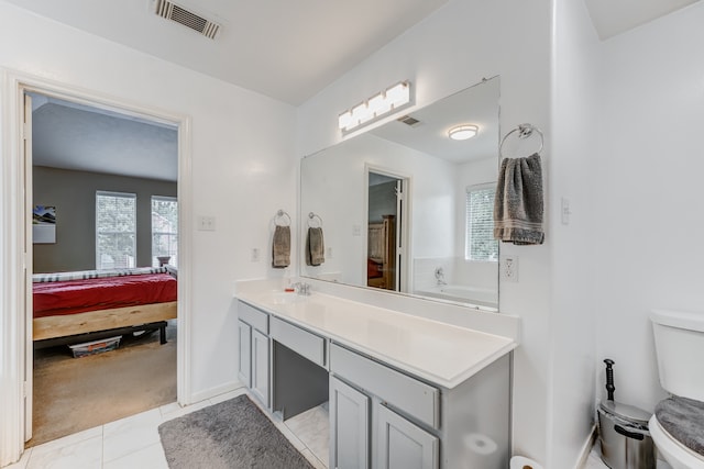 bathroom with toilet, tile flooring, and vanity