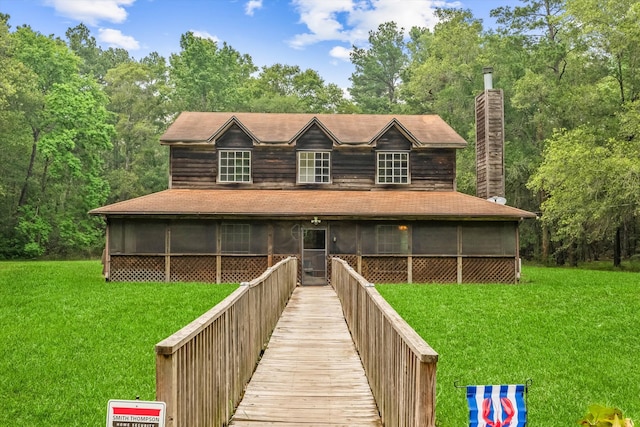 view of front of property with a sunroom and a front lawn