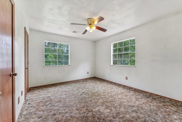 carpeted empty room with plenty of natural light and ceiling fan