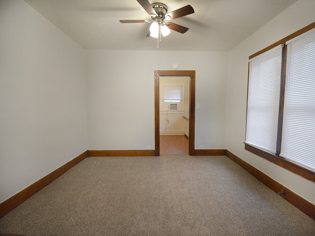 carpeted spare room featuring ceiling fan and a healthy amount of sunlight