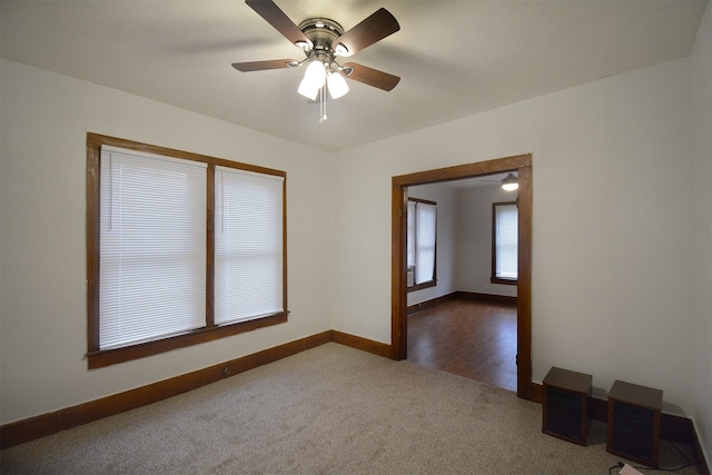 unfurnished room featuring dark colored carpet and ceiling fan