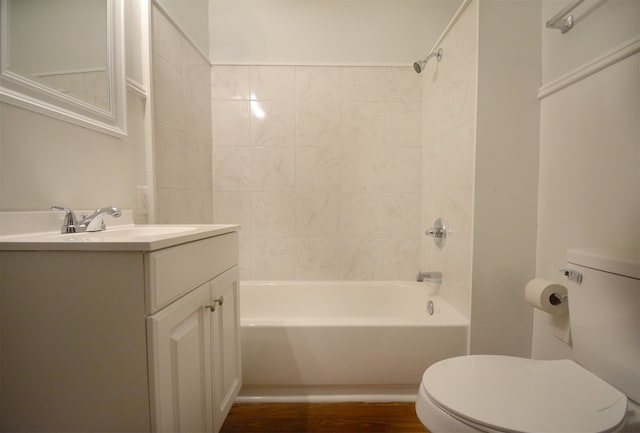 full bathroom with tiled shower / bath, vanity, hardwood / wood-style flooring, and toilet