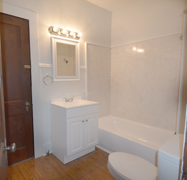 full bathroom featuring bathing tub / shower combination, toilet, vanity, and hardwood / wood-style floors