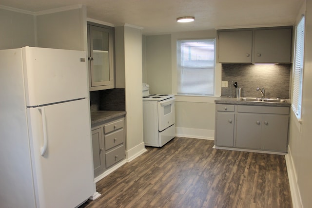 kitchen with dark hardwood / wood-style flooring, white appliances, and tasteful backsplash