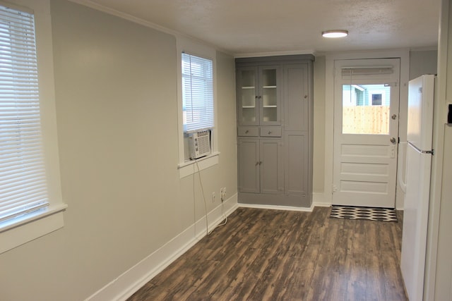 doorway featuring dark hardwood / wood-style flooring, crown molding, and a textured ceiling